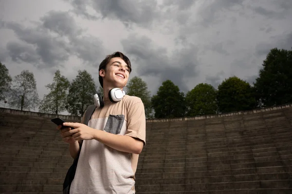 Positive Happy Teenager Boy Using Phone Dramatic Sky Student Smiling — Stockfoto