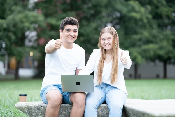 Casal Adolescente Com Polegares Para Cima Sorrindo Olhando Para Câmera — Fotografia de Stock