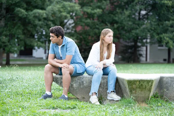 一对愤怒而悲伤的青少年夫妇坐在公园外面 — 图库照片