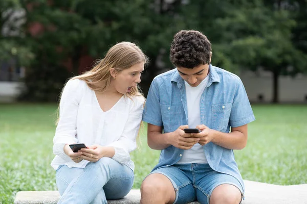 Überraschtes Teenager Mädchen Spioniert Handy Freund Freien Einem Park Aus — Stockfoto