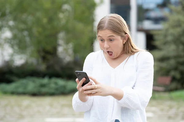Überraschtes Skandinavisches Teenagermädchen Das Draußen Auf Sein Handy Schaut Gefahrenkonzept — Stockfoto