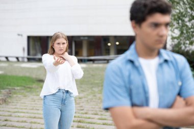 Genç kız üzgün ve kızgın erkek arkadaşına af diliyor. Oğlan kız arkadaşını terk ediyor