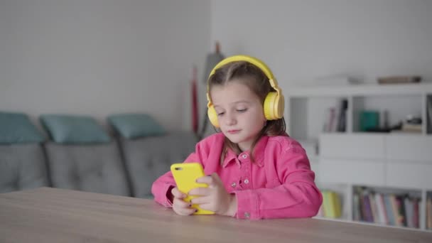 Roztomilé Holčička Nosí Sluchátka Pomocí Telefonu Brát Selfie Doma — Stock video