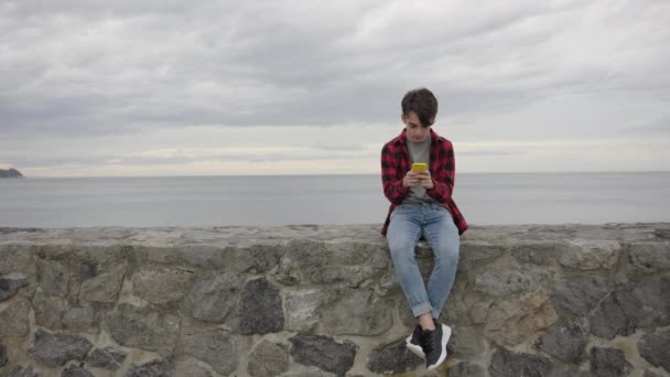 Cute Teenager Boy Using Phone Taking Selfie Coastline Static Shot — Stock Video