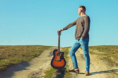 Adam elinde gitarla pistte. Gitarlı adam.