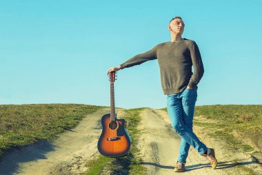 Gitarla yollarda. Genç adam ve gitar.