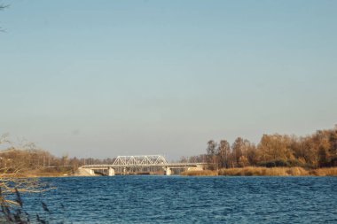 Rezervuarın üzerindeki köprü. Gölün kıyısından manzara manzarası. Sonbahar zamanı