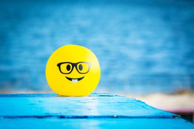 Mutlu gülücükler. Kumsalda dinlen. Mutluluk duygusu. Mavi arkaplan