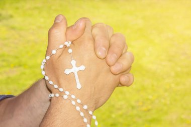 Ellerinde haç var. Tanrı 'ya dua et. Tanrıya inan.