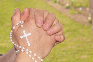 Ellerin duayla bağlandı. Tanrı 'ya dua et. Ellerinde haç