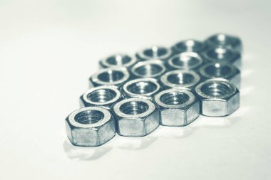 Beyaz arka planda metal yuvarlak fındıklar. Altıgen yeni fındık