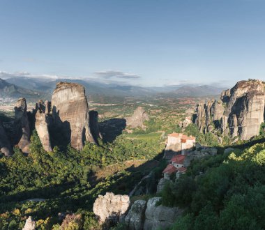 Manastır Meteora Yunanistan. Yaz panoramik manzara çarpıcı. Dağlar ve epik mavi gökyüzü bulutlu yeşil orman görüntüleyin. UNESCO miras listesi nesnesi.