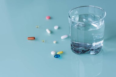 Tabletler ve bir bardak su tablo