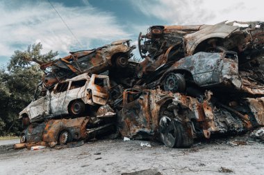 BUCHA, UKRAINE 22.06.2022 Irpin, Bucha. Araba mezarlığı. Savaşın sonucu olarak arabalar yok edildi. Bir araba dağı yandı..