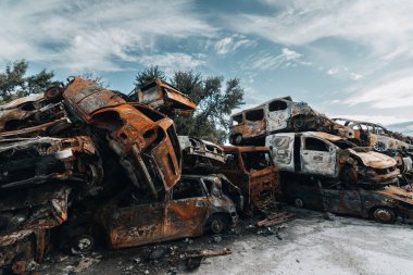 BUCHA, UKRAINE 22.06.2022 Irpin, Bucha. Araba mezarlığı. Savaşın sonucu olarak arabalar yok edildi. Bir araba dağı yandı..