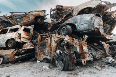 BUCHA, UKRAINE 22.06.2022 Irpin, Bucha. Araba mezarlığı. Savaşın sonucu olarak arabalar yok edildi. Bir araba dağı yandı..