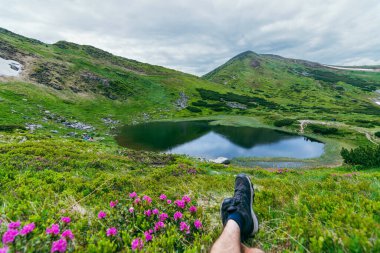 Ukrayna Karpatları 'ndaki Nesamovyte Gölü. Ukrayna Karpatlarının gökyüzü ve bulutların arka planında asılı duran Hoverla Dağı.