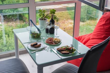 Biftekli ve kırmızı şaraplı iki kişilik yemek.