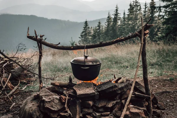 暗い大きな鍋や釜 公園や山のどこかの火の上に沸騰した水で鍋を調理 キャンプのコンセプト — ストック写真