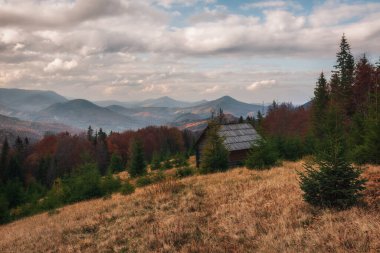 Ukrayna 'nın güzel dağları. Dağların arkasındaki eski ahşap ev. Karpatlar, Ukrayna