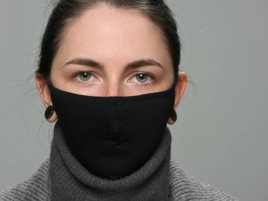 Siyah arka plan 2021 'de siyah COVID maskeli esmer kız.