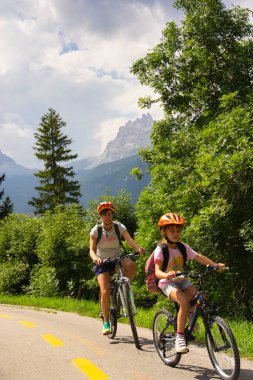 Belluno, İtalya - 17 Ağustos 2018: İtalya 'nın Dolomitleri' nin dağlık kesimindeki tatil beldesi, Cortina d Ampezzo. Bisikletçiler 2021 yolunda.