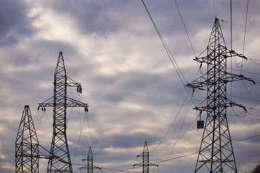 2021 yılının fırtınalı gökyüzüne karşı yüksek voltajlı sütunlar