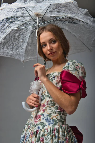 2021年の灰色の背景に太陽からの傘を持つ優しい女の子 — ストック写真