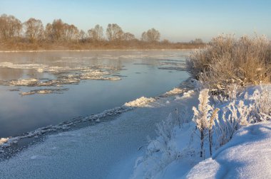 winter landscape. morning frost and sun. ice drift on the river. the branches of plants are covered with white frost 2022