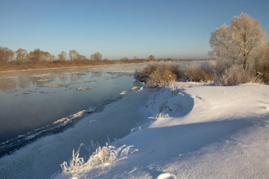 winter landscape. morning frost and sun. ice drift on the river. the branches of plants are covered with white frost 2022