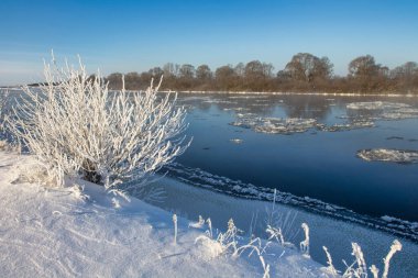 winter landscape. morning frost and sun. ice drift on the river. the branches of plants are covered with white frost 2022