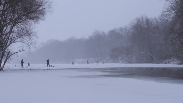 雪が降る川での冬の釣り — ストック動画