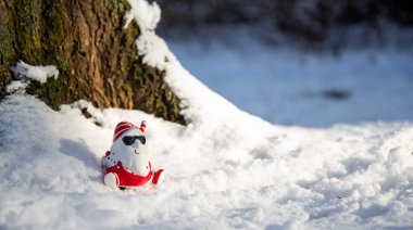 Karda güneş gözlüğü olan havalı komik Noel Baba. 