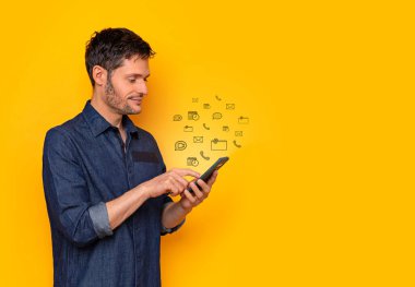 Genç adam akıllı telefonuyla mesajları kontrol ediyor.