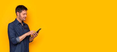 Genç adam akıllı cep telefonunu kullanıyor.