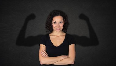 Arkaplanda güçlü kol gölgesi olan genç ve güzel bir kadın.