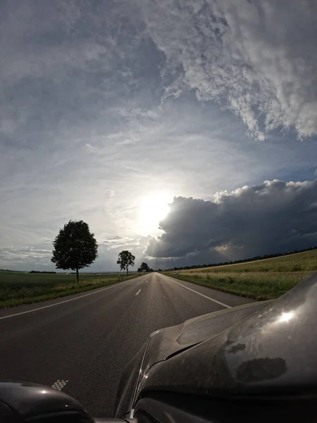 Uzun cadde bulutlu gökyüzünde araç sürüyorum.