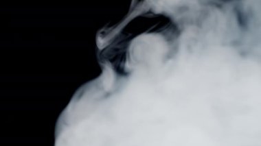 Vape smoke. Thick gray smoke is blowing from left to right. Thick smog. Cigarette smoke on black background 4k resolution