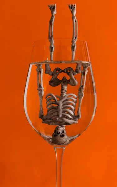 Menselijk Skelet Mannequin Een Wijnglas Tegenovergestelde Oranje Achtergrond — Stockfoto