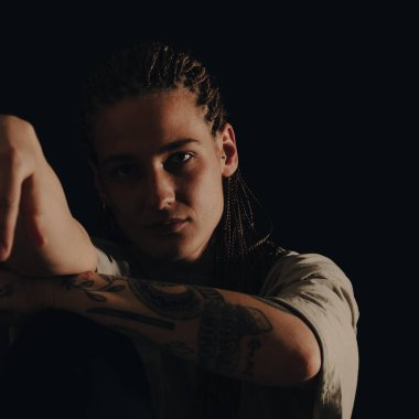 Dövmeleri, piercingleri ve örgülü saç portresi olan ciddi bir şehirli kadın..