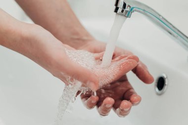 Kız enfeksiyonu önlemek için ellerini yıkar. Virüs COVID-19.