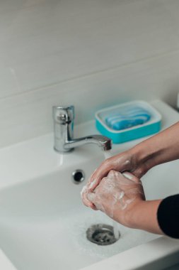 Kız enfeksiyonu önlemek için ellerini yıkar. Virüs COVID-19.