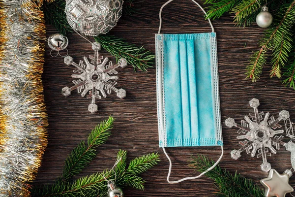 Ramas del árbol de Navidad y máscara en un fondo marrón —  Fotos de Stock