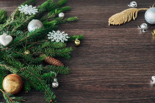 Weihnachtsbaumzweige und Schneeflocken auf braunem Hintergrund mit Kopierraum — Stockfoto