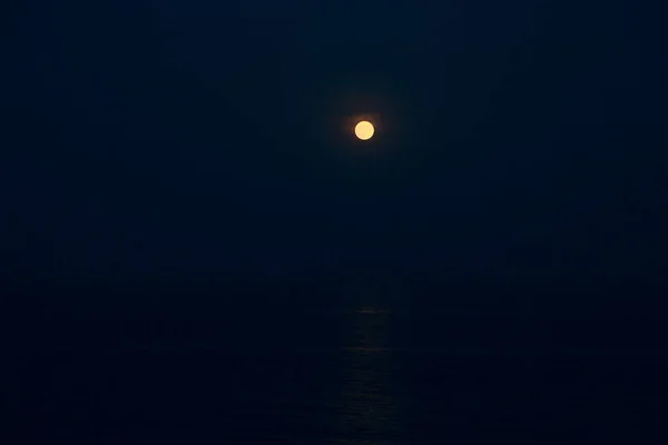 Luna Roja Llena Brilla Brillantemente en el Cielo Azul en una Noche Sobre el Mar — Foto de Stock