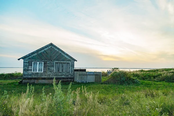 Old Wooden House by the Sea. Чудесный пейзаж с закатом — стоковое фото