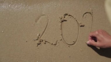 Kelime 2022 Plajın Kumu 'nda yazıldı. Yeni Yıl 2022 Deniz Sahilinde metin