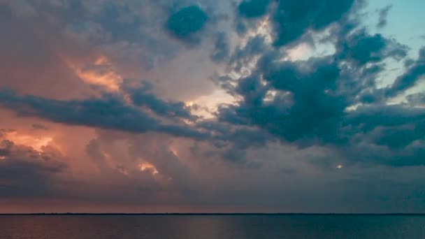 TimeLapse pięknego krajobrazu zachodu słońca na plaży. Spokojna pogoda z ciemnymi chmurami na Złotym Niebie odbita w wodzie — Wideo stockowe