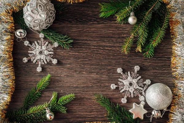 Ramas de árboles de Navidad y copos de nieve sobre un fondo marrón con espacio de copia —  Fotos de Stock