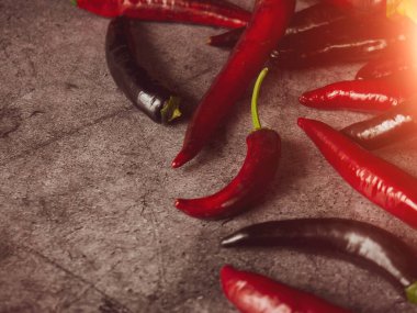 Koyu beton zemin üzerinde kırmızı ve siyah biber kabukları
